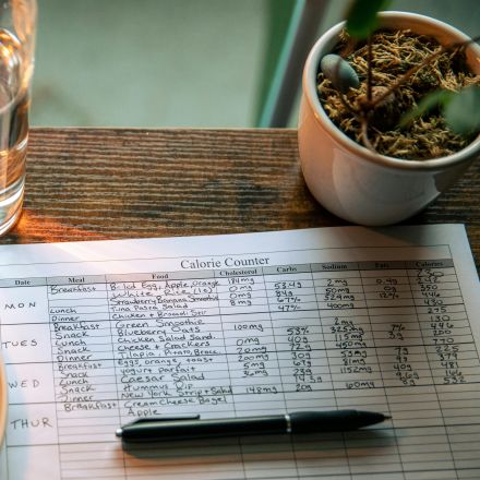 Clear Drinking Glass Beside Black Pen on White Paper